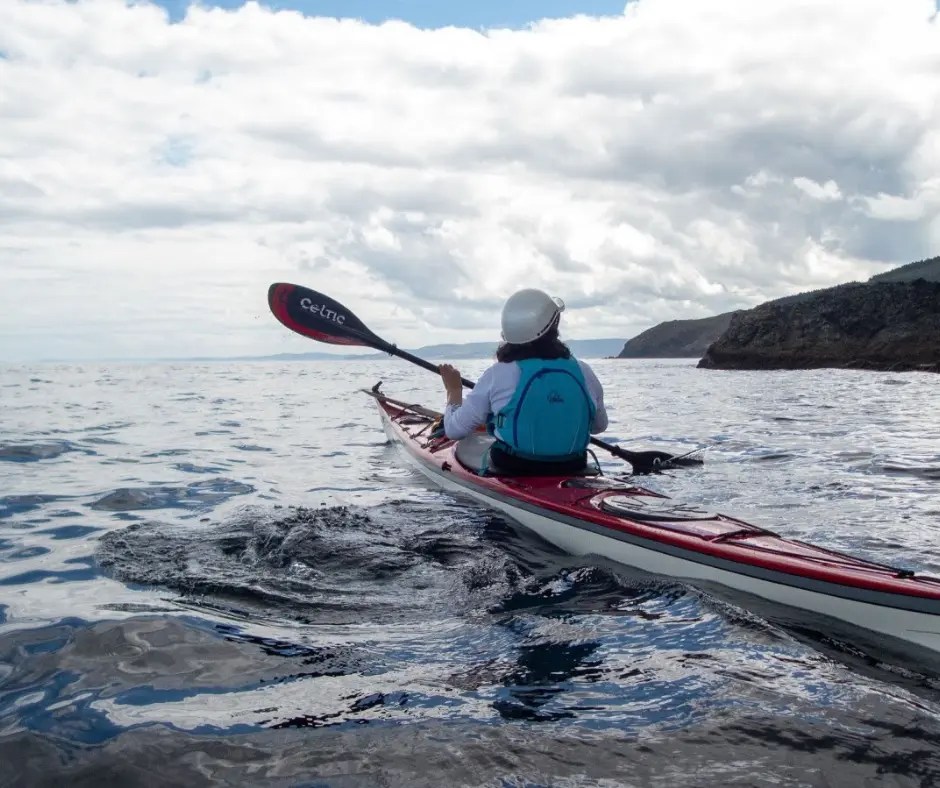 Kayakista practicando el control de cantos y maniobras de precisión en el mar.