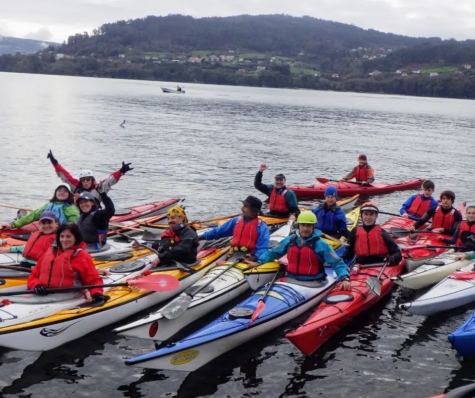Gran grupo de palistas con chalecos salvavidas en una salida grupal por el mar.